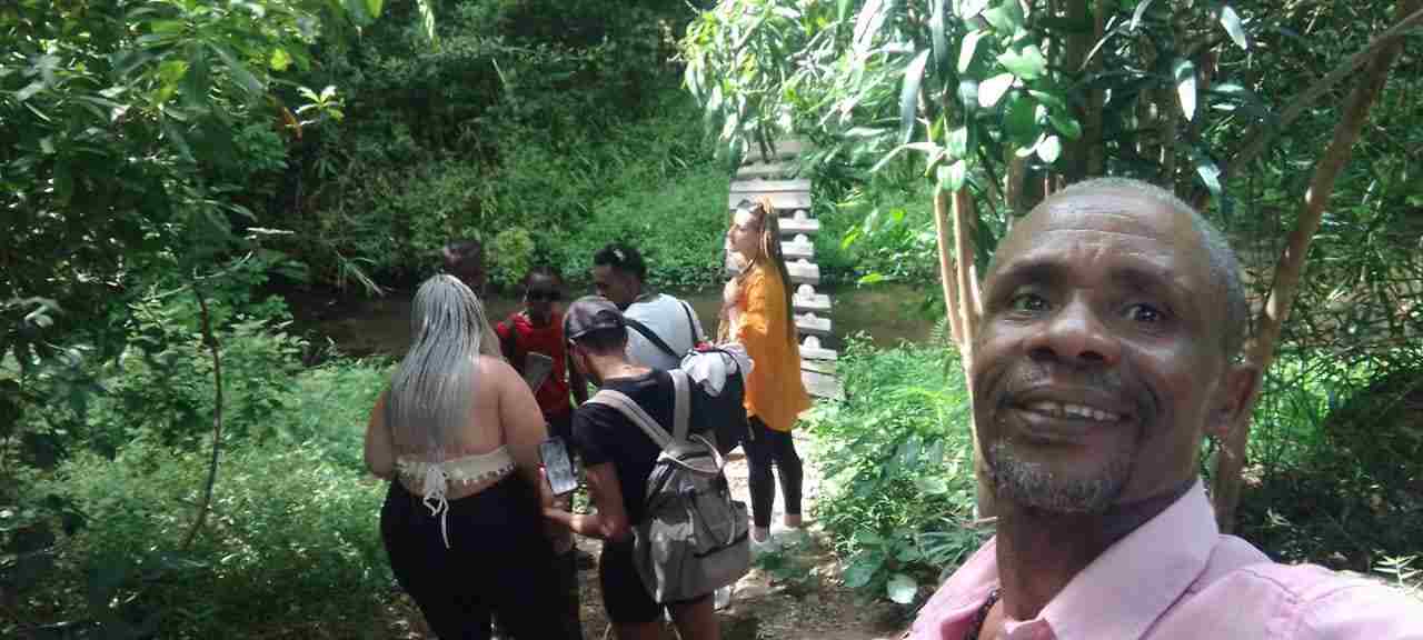 Guide and guests crossing a stream bridge